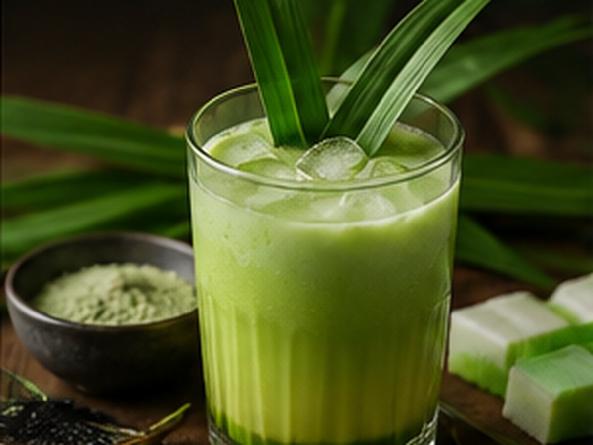 Pandan leaves beside a green pandan coconut beverage